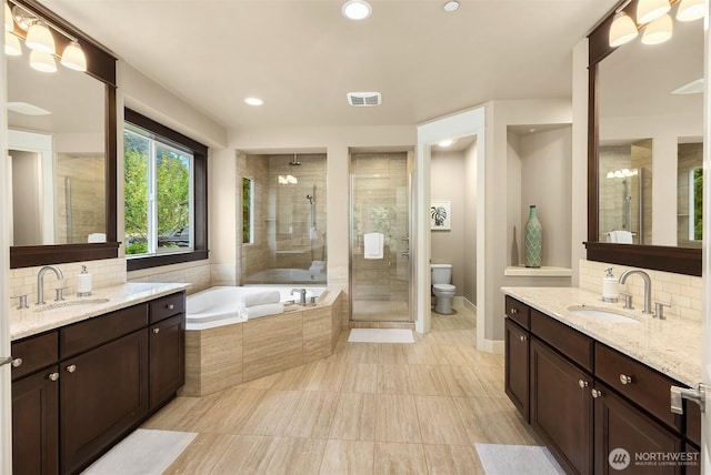 bathroom with a sink, visible vents, a stall shower, and a bath
