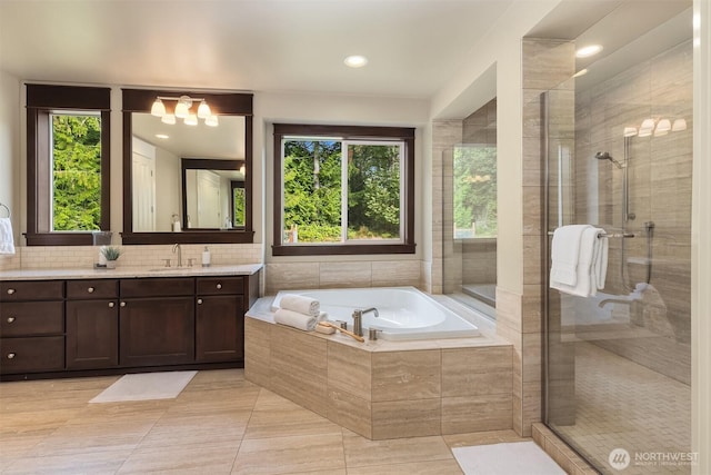 full bath featuring a stall shower, vanity, and a garden tub