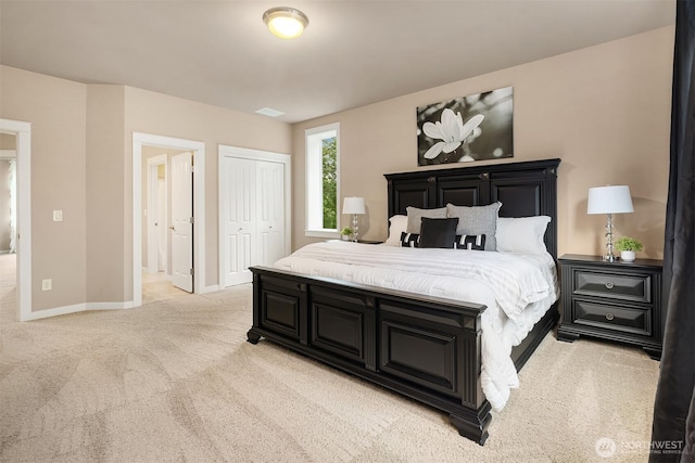 bedroom featuring a closet, baseboards, and light colored carpet