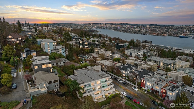 aerial view at dusk featuring a water view