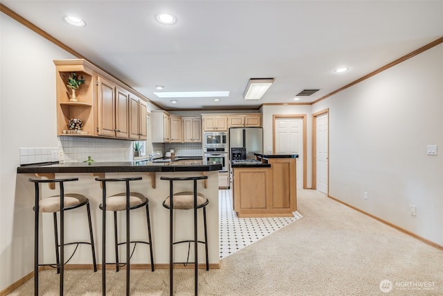 kitchen featuring crown molding, a kitchen breakfast bar, a peninsula, stainless steel appliances, and visible vents