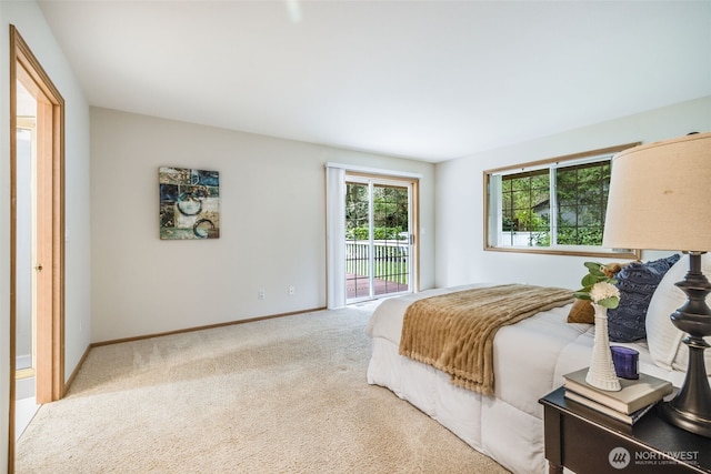 carpeted bedroom featuring baseboards and access to outside