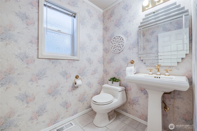 bathroom with toilet, baseboards, tile patterned floors, wallpapered walls, and visible vents