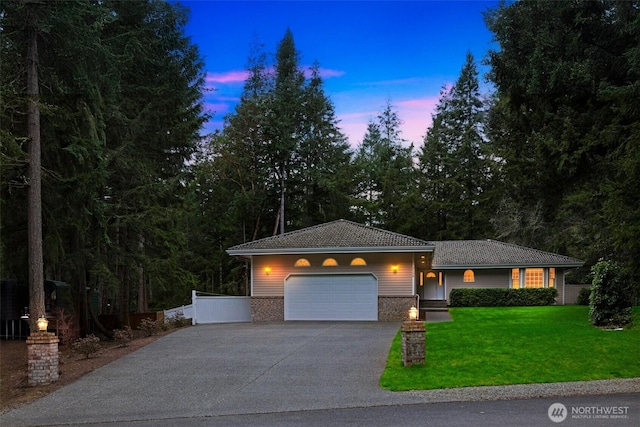 view of front of house with a garage, concrete driveway, a front yard, a tile roof, and brick siding