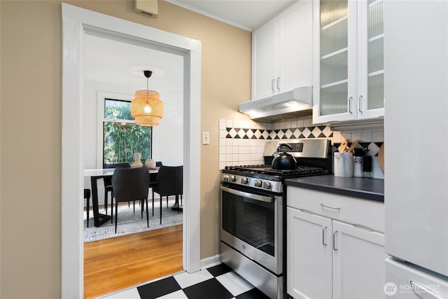4712 S Angeline St, Seattle, WA 98118 - kitchen with tasteful backsplash, under cabinet range hood, light floors, stainless steel gas stove, and white cabinets