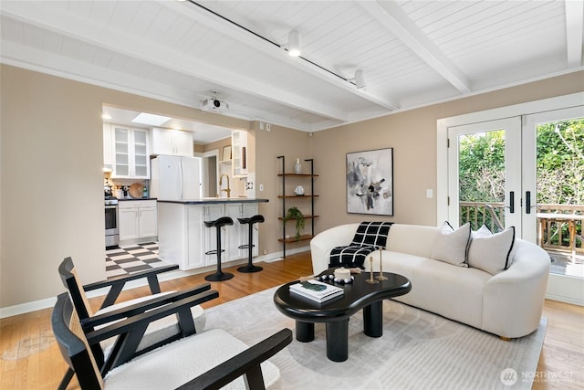 4712 S Angeline St, Seattle, WA 98118 - living area featuring beam ceiling, track lighting, light wood finished floors, and baseboards