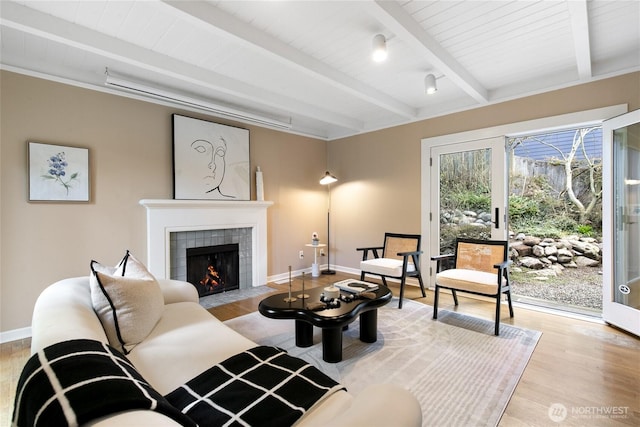 4712 S Angeline St, Seattle, WA 98118 - living area with beamed ceiling, baseboards, light wood-style flooring, and a tiled fireplace