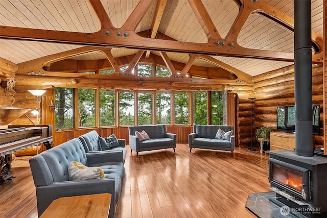 living room featuring hardwood / wood-style floors, lofted ceiling with beams, wooden ceiling, and a wood stove
