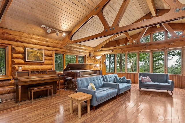 living room with hardwood / wood-style floors, rail lighting, wooden ceiling, and beam ceiling
