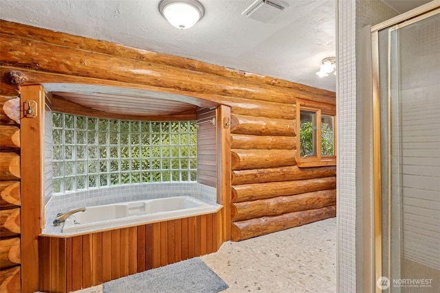 full bathroom featuring a bath, a textured ceiling, visible vents, and rustic walls