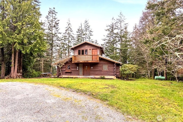 view of front of house with log siding and a front yard