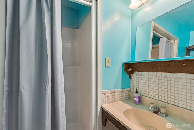 bathroom featuring vanity, decorative backsplash, and curtained shower