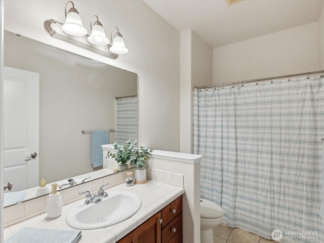 bathroom featuring vanity, tile patterned floors, and toilet