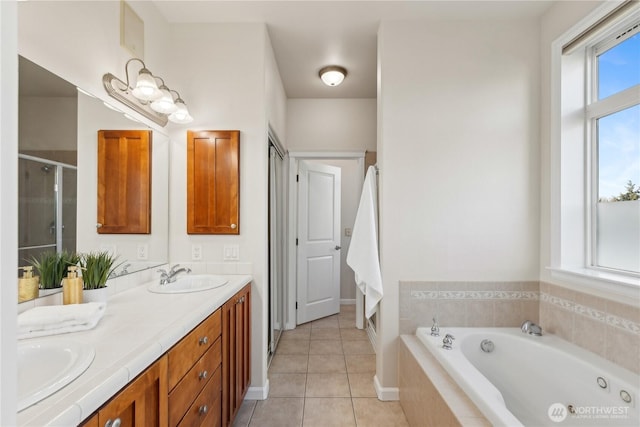 bathroom with tile patterned flooring, a shower stall, a jetted tub, and a sink