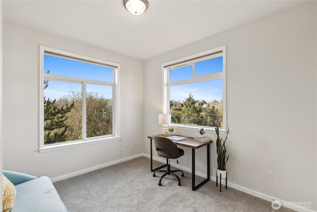 office area featuring light carpet and baseboards