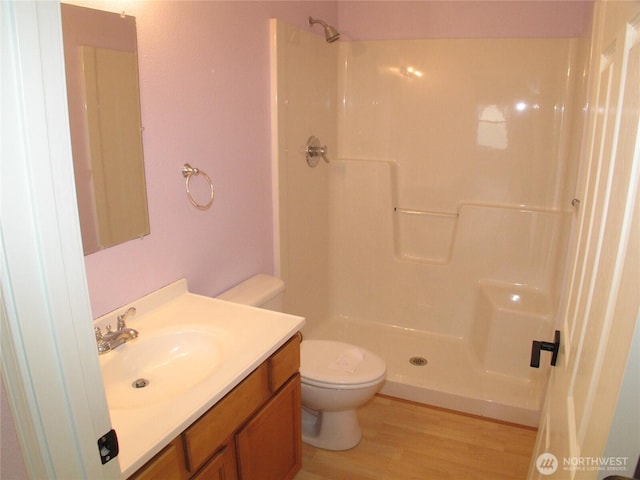 full bath featuring a shower, toilet, vanity, and wood finished floors