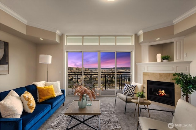 carpeted living area with a glass covered fireplace and ornamental molding