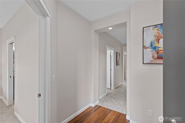 corridor with dark wood finished floors and baseboards