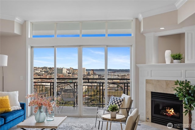 living area featuring a tiled fireplace, a view of city, and crown molding