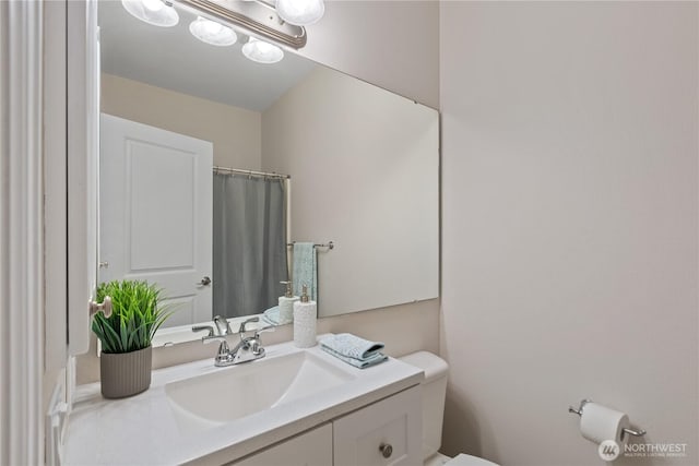full bath featuring toilet, vanity, and a shower with curtain