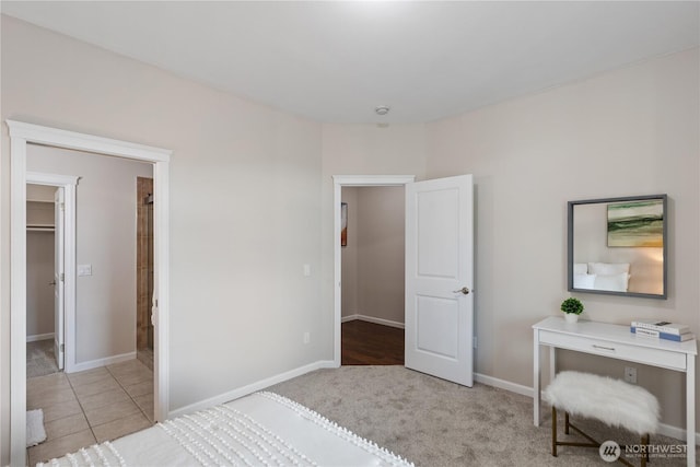 tiled bedroom featuring carpet flooring, baseboards, and a spacious closet