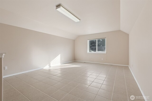 6719 Prairie Ridge Dr NE, Olympia, WA 98516 - empty room featuring light tile patterned floors, baseboards, and lofted ceiling