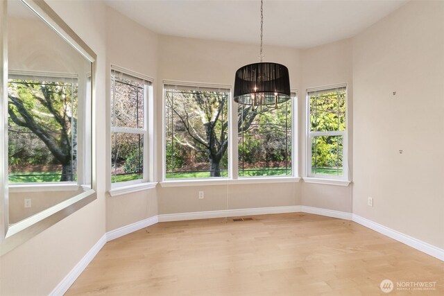 6719 Prairie Ridge Dr NE, Olympia, WA 98516 - spare room with a wealth of natural light, baseboards, an inviting chandelier, and light wood finished floors