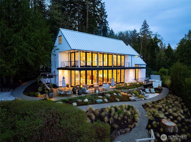 9844 NE Lafayette Ave, Bainbridge Island, WA 98110 - back of property featuring an outdoor living space, a patio, metal roof, and a balcony
