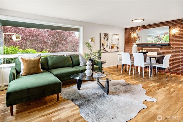 living room featuring brick wall and wood finished floors