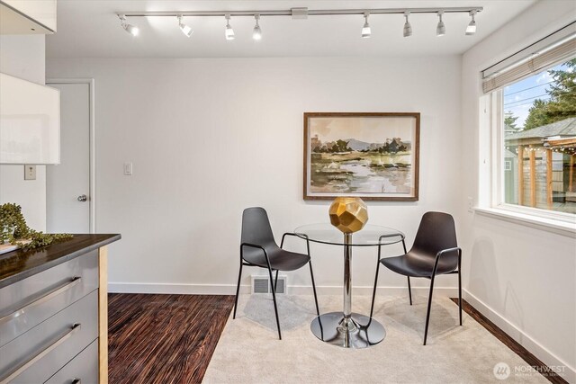 sitting room featuring baseboards, rail lighting, dark wood-style floors, and visible vents