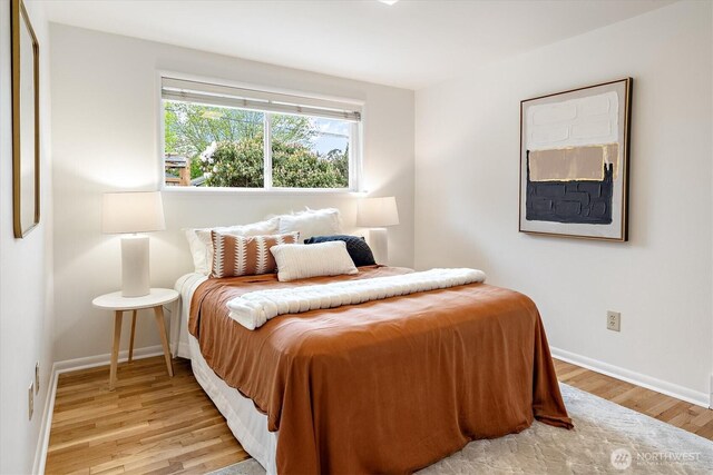bedroom with light wood-style floors and baseboards