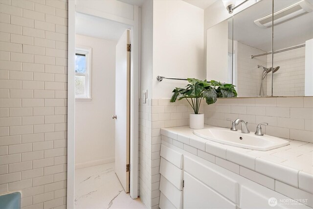bathroom with a shower, marble finish floor, and vanity