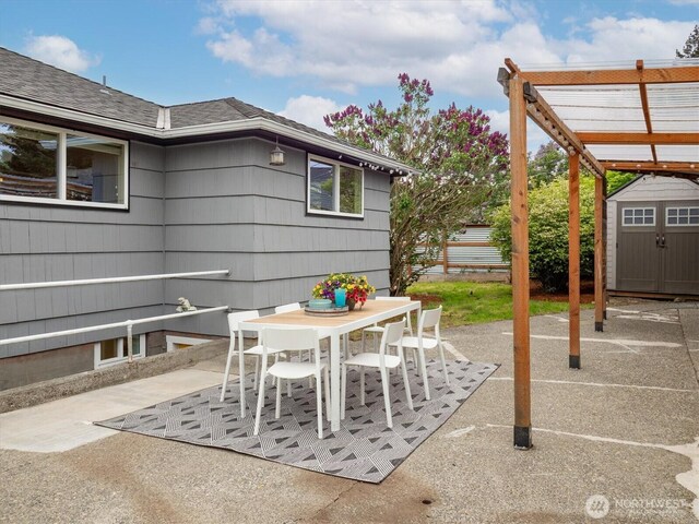 view of patio with a storage shed, an outbuilding, and outdoor dining space