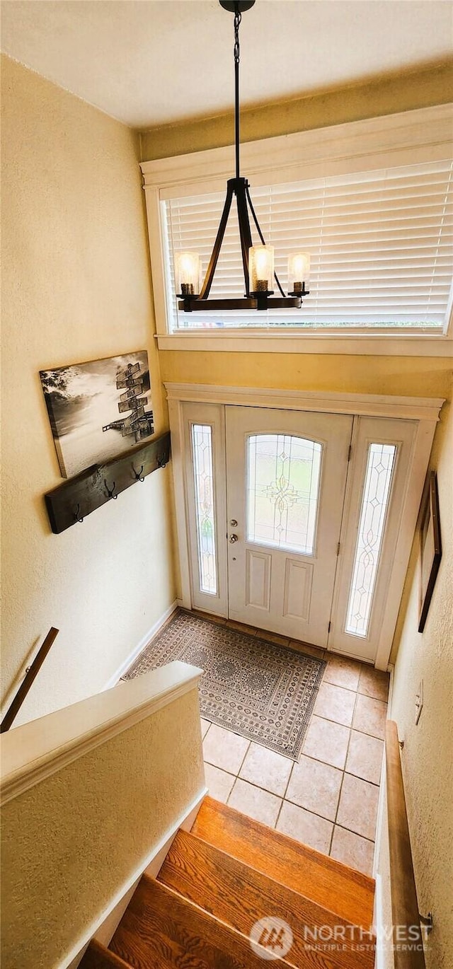 entrance foyer with an inviting chandelier and light tile patterned floors