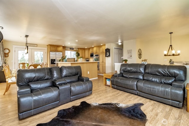 living area featuring a notable chandelier and light wood finished floors