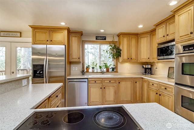 kitchen featuring a sink, stainless steel appliances, light stone counters, and recessed lighting