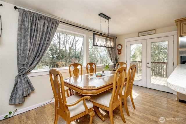 dining area featuring french doors, light wood-style flooring, and a wealth of natural light