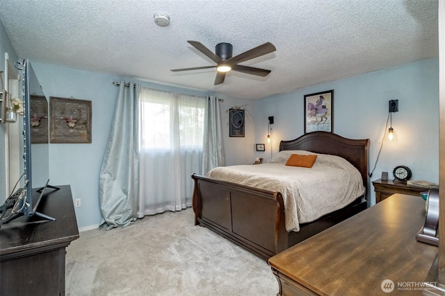 bedroom with light carpet, baseboards, ceiling fan, and a textured ceiling