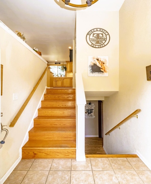 stairs with tile patterned floors and baseboards