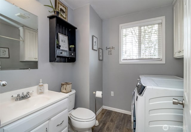 bathroom with visible vents, independent washer and dryer, baseboards, toilet, and wood finished floors