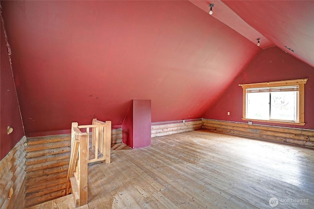 additional living space featuring vaulted ceiling and hardwood / wood-style floors