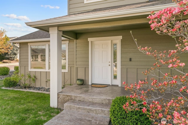doorway to property with roof with shingles