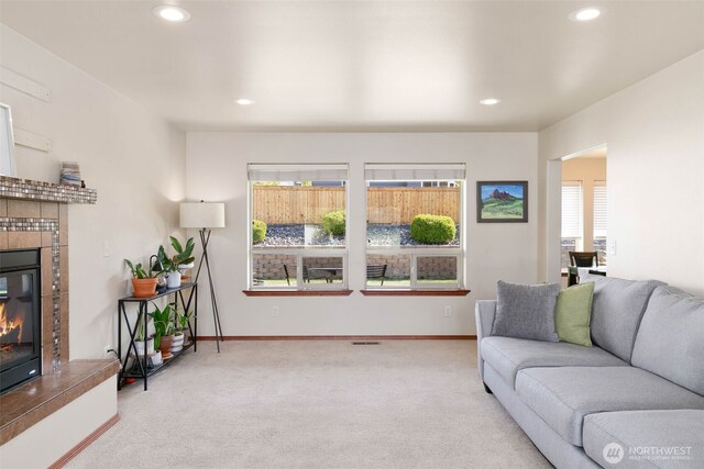 carpeted living area featuring recessed lighting, baseboards, visible vents, and a tiled fireplace
