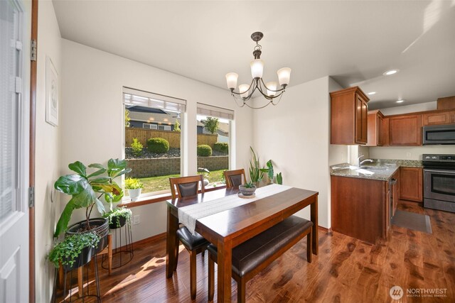 dining space with recessed lighting, baseboards, a notable chandelier, and dark wood-type flooring