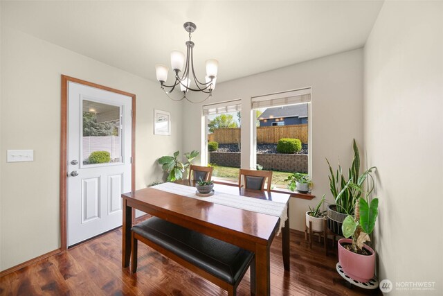 dining space featuring wood finished floors and a chandelier