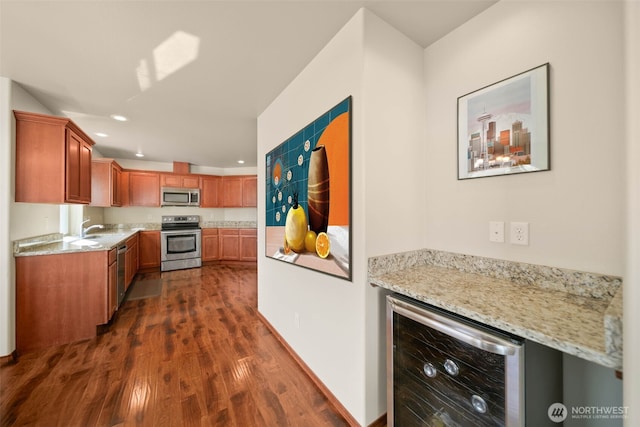 kitchen with dark wood-style flooring, appliances with stainless steel finishes, light stone counters, recessed lighting, and wine cooler