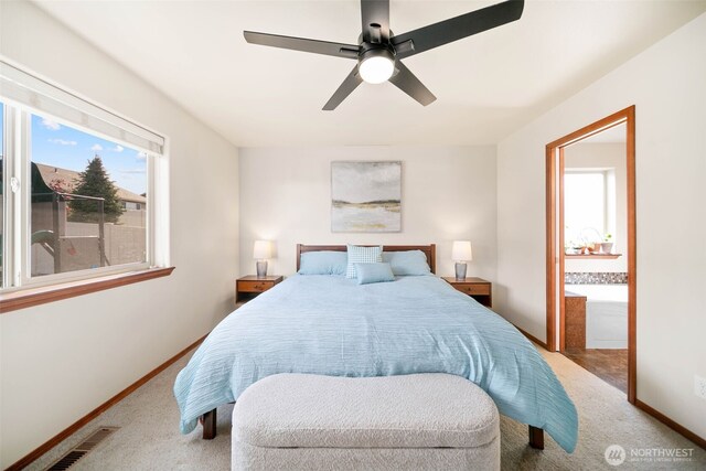 bedroom with carpet flooring, baseboards, multiple windows, and ensuite bath
