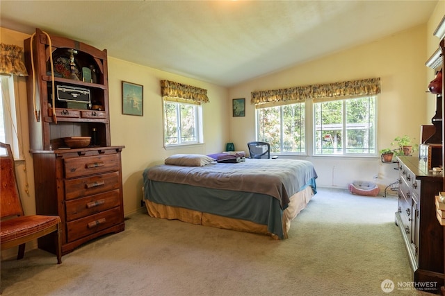 carpeted bedroom with lofted ceiling