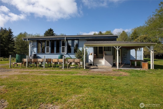 rear view of property featuring a lawn