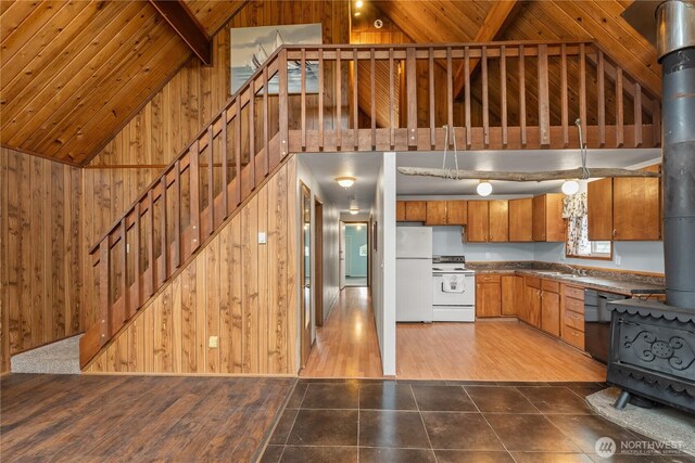 1205 Fairwood Dr SW, Ocean Shores, WA 98569 - kitchen featuring wooden walls, wood ceiling, a wood stove, brown cabinetry, and white appliances